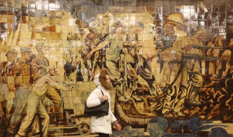 Woman walks along tunnel with fragment of interior design seen in background at Komsomolskaya metro station on Sokolnicheskaya line in Moscow