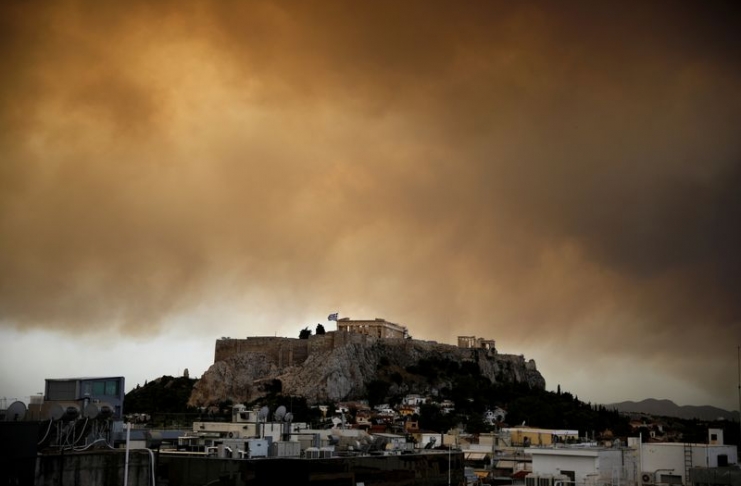 Smoke from a wildfire burning outside Athens is seen over the Parthenon temple atop the Acropolis hill in Athens