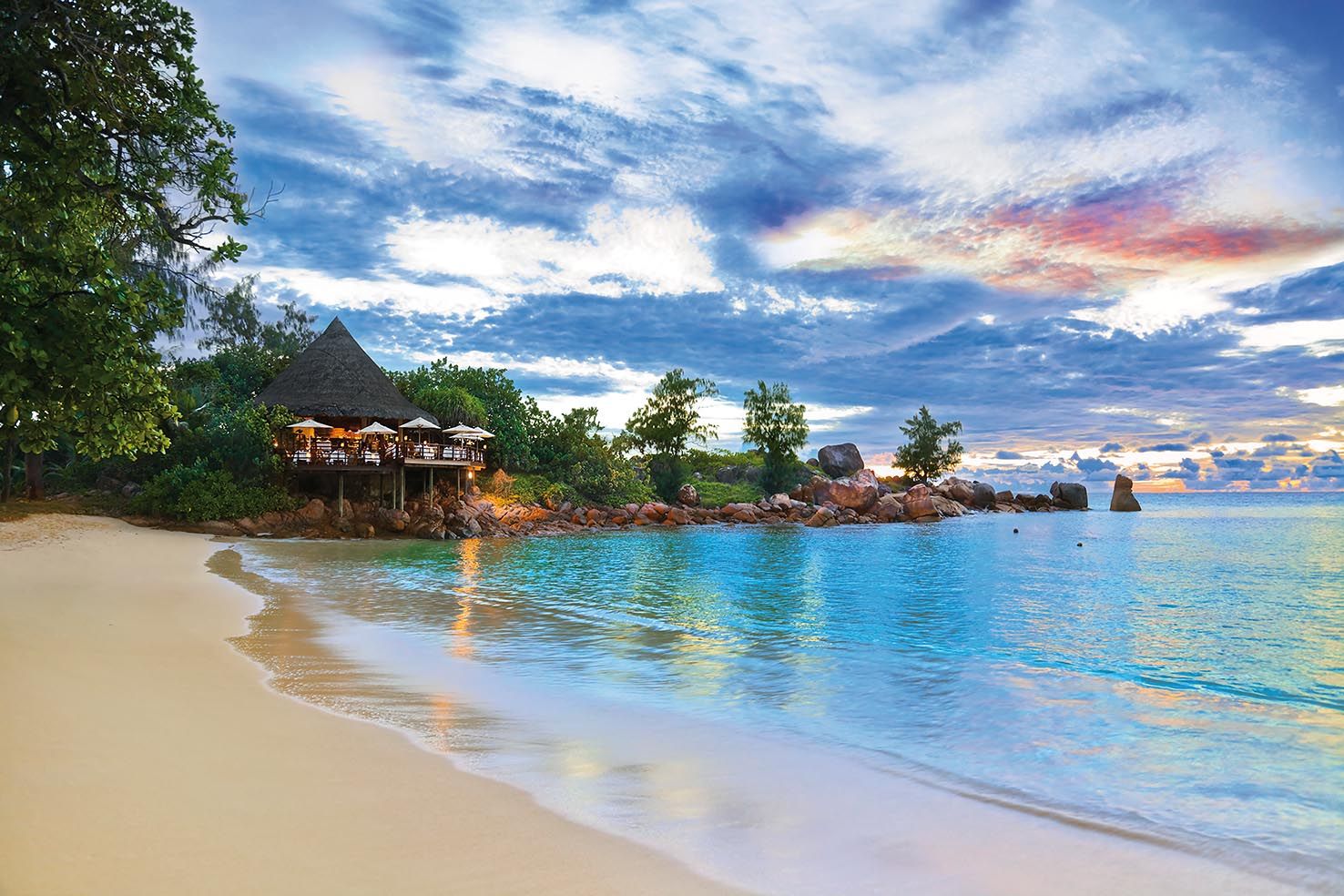 Cafe on tropical beach at sunset