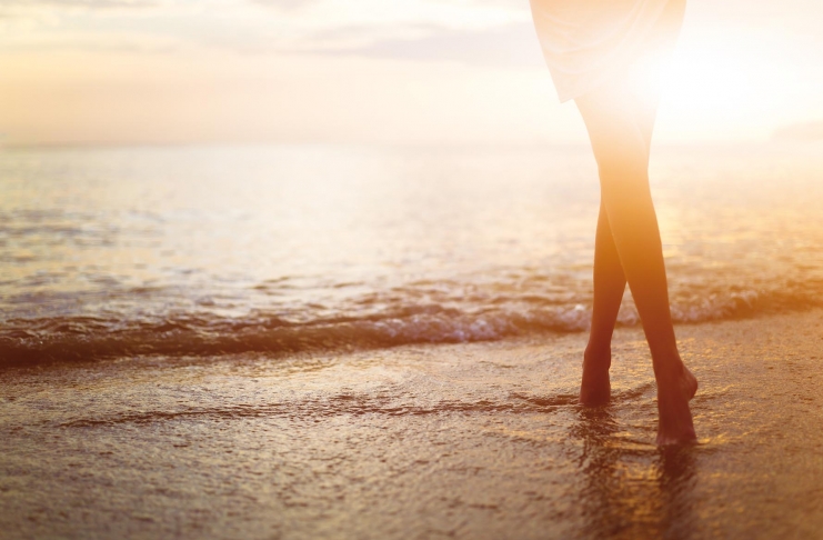 Woman near the ocean. Sunset time.