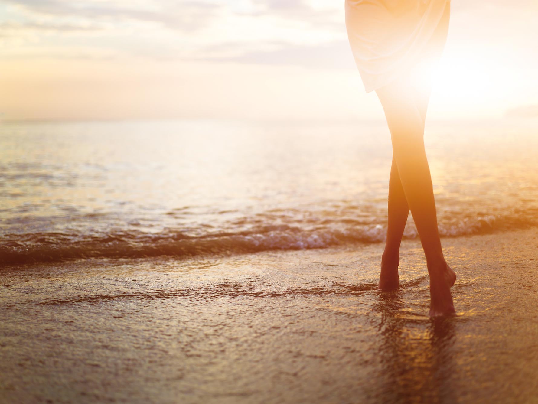 Woman near the ocean. Sunset time.