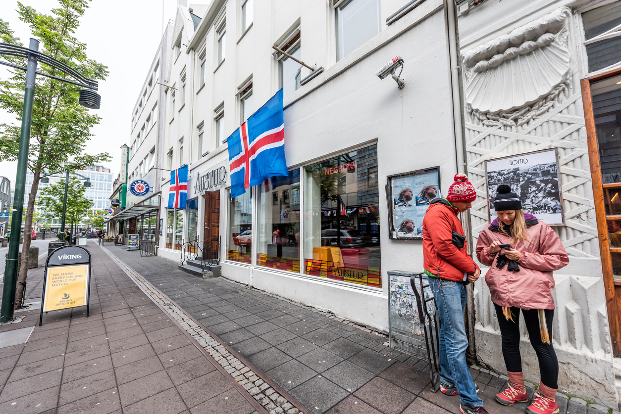 Street road sidewalk in downtown center and flags sign for Austur nightclub and couple lost
